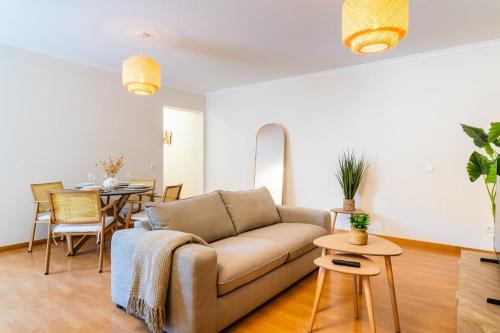 een woonkamer met een bank en een tafel bij GuestReady - The perfect hideout in Caniço in Caniço