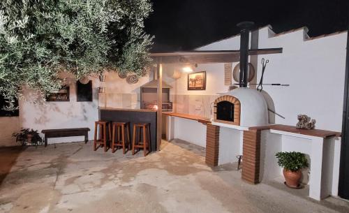 a kitchen with an outdoor kitchen with a fireplace at Cortijo Atalaya de Loaimes in Granada