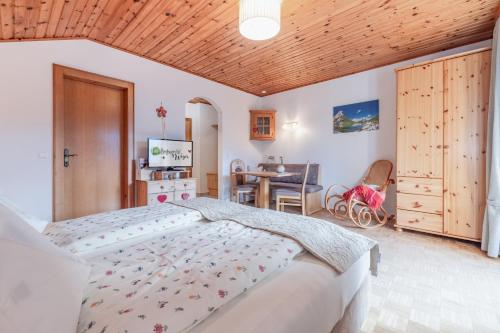 a bedroom with a large bed and a table at Bio-Bergbauernhof Weger in Dellach