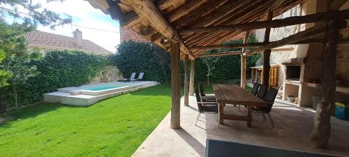 a patio with a table and chairs and a pool at Casa de las Eras in Valdesimonte