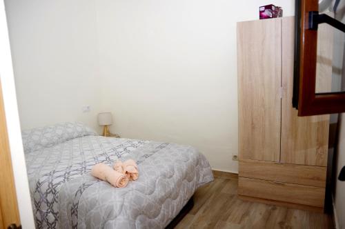 Refugio tranquilo cerca de las piscinas في كانديليدا: غرفة نوم بها سرير عليه حيوان محشو