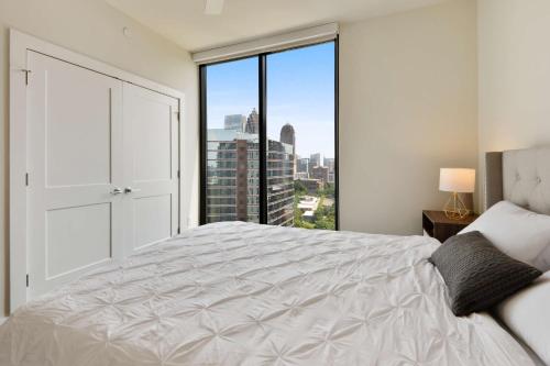 a bedroom with a white bed and a large window at Amazing Midtown 2 bdrm in Atlanta