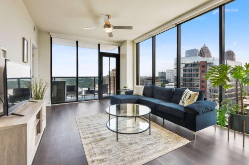 a living room with a blue couch and a glass table at Amazing Midtown 2 bdrm in Atlanta