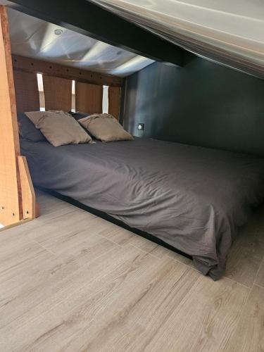 un letto grande in una stanza con un muro di Chez MariLou a Ambérieu-en-Bugey