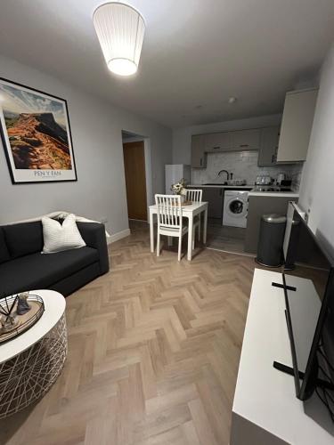 a living room with a couch and a kitchen at The Loft in Merthyr Tydfil
