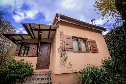 een klein huisje met een deur en ramen bij Green Hideaway in Fîntînele