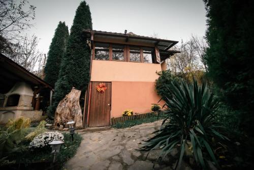 een huis met een grote houten deur in een tuin bij Green Hideaway in Fîntînele