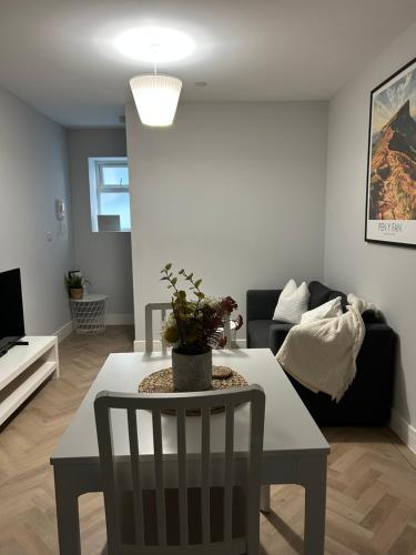 a living room with a table and a couch at The Loft in Merthyr Tydfil