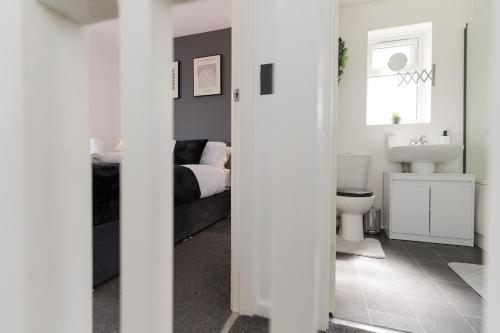 a white bathroom with a bed and a sink at Contractors-Relocation-Free Parking-M5 Junction2 in Oldbury