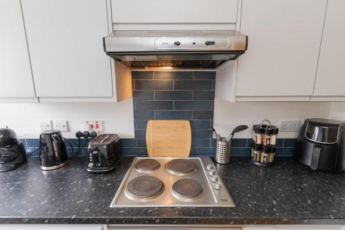 a kitchen counter with a stove with donuts on it at Contractors-Relocation-Free Parking-M5 Junction2 in Oldbury