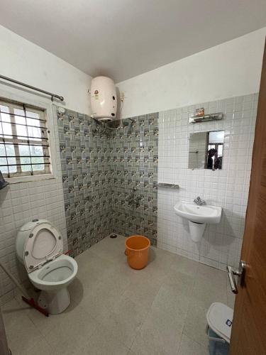a bathroom with a toilet and a sink at Sathya Holidays Evermist Stay in Ooty
