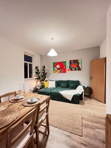 a living room with a green couch and a table at Liebe Wohnung Pension in Penig