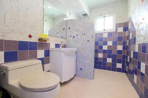 a bathroom with a toilet and a mirror at Edinburgh 16 Inn in Hengchun