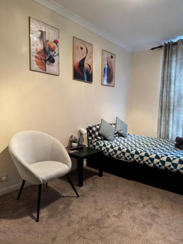 een slaapkamer met een bed en een stoel bij Smart Junction in Norwood