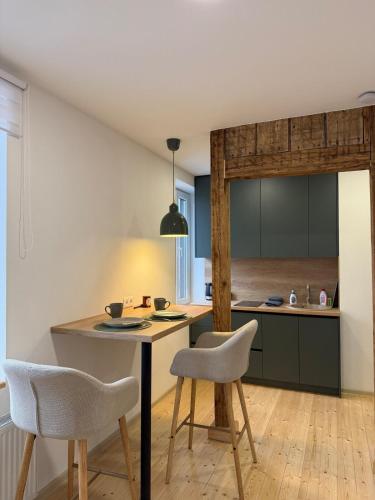 a kitchen with a table and two chairs at Green apartment in Jelgava