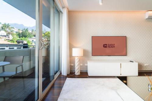 a living room with a tv on a wall at GuestReady - Premium stay in Funchal in Funchal