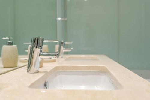 a bathroom sink with two faucets on a counter at GuestReady - Premium stay in Funchal in Funchal