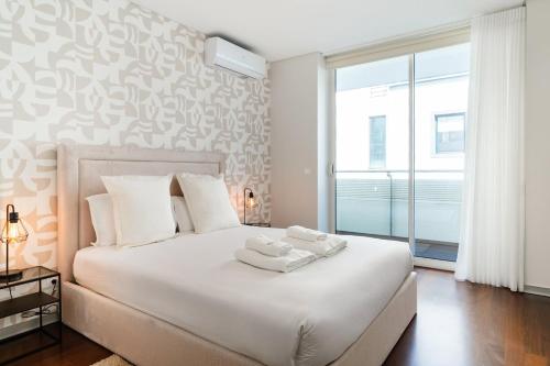 a bedroom with a white bed with two towels on it at GuestReady - Premium stay in Funchal in Funchal