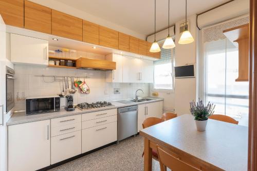 eine Küche mit weißen Schränken und einem Tisch in der Unterkunft La Piazzetta in San Giovanni in Persiceto