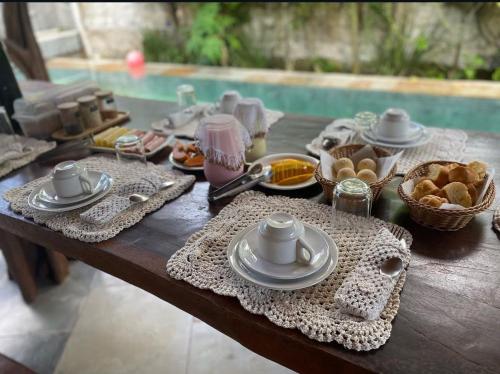 een tafel met borden en kommen met eten erop bij Pousada Casinha Branca in Cruz