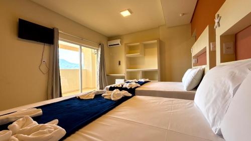 um quarto de hotel com duas camas com toalhas em Oasis do Mar Hotel - A melhor vista de Itapema em Itapema