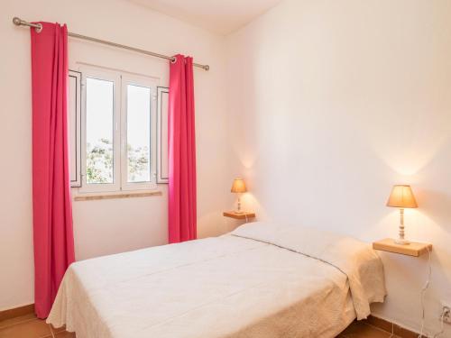 a bedroom with a bed and a window with red curtains at Akivillas Lagos Zircon in Lagos