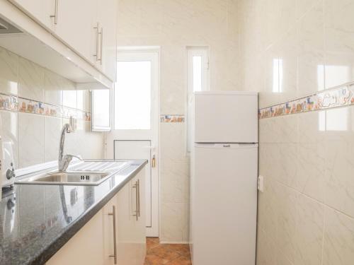 a white kitchen with a refrigerator and a sink at Akivillas Lagos Zircon in Lagos