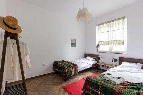 a room with two beds and a hat on a tripod at Gora Apartments in Vrdnik