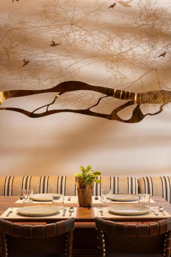uma sala de jantar com uma mesa com cadeiras e um mural de árvore em The Sylvan Lodge at Snake River Sporting Club em Jackson