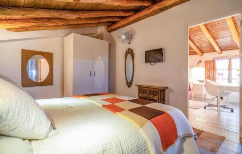 Un dormitorio con una cama y un escritorio en una habitación. en Impresionante casa molino, en Benadalid