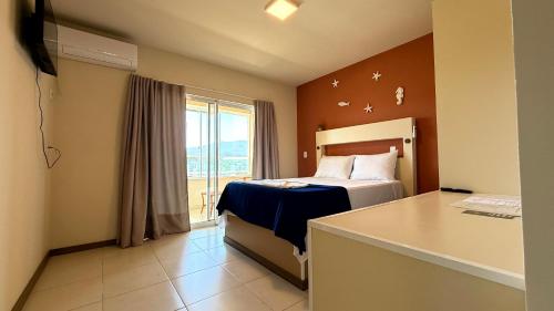 a hotel room with a bed and a window at Oasis do Mar Hotel - A melhor vista de Itapema in Itapema