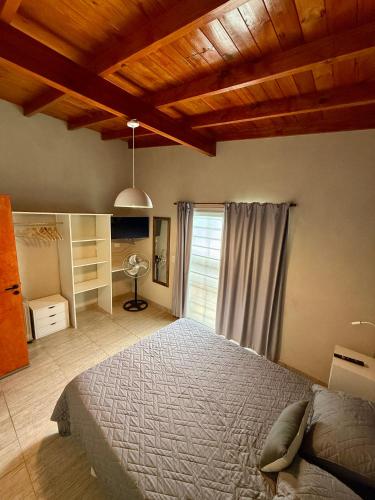 Un dormitorio con una cama y un techo de madera. en Departamentos Norte 2, en Villa Gesell