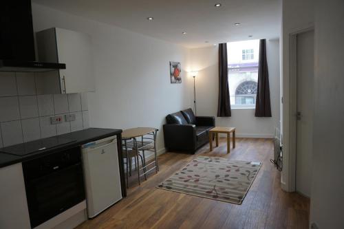 cocina y sala de estar con sofá y mesa en Town Centre Apartments en Dewsbury