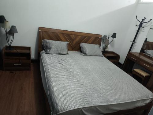 a bed with two pillows on it in a bedroom at Studio chambre salon cuisine in Dakar