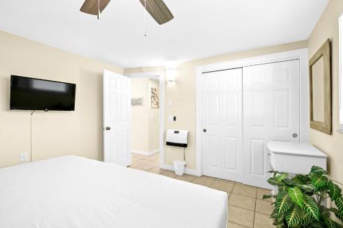 een slaapkamer met een wit bed en een badkamer bij Sun Baker II South in Anna Maria Island