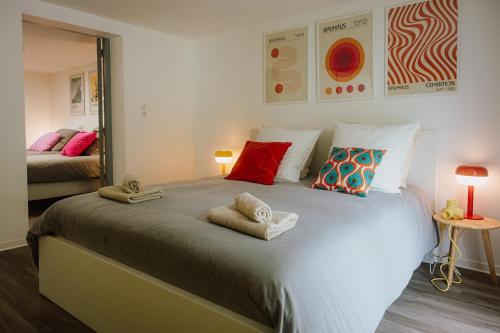 a bedroom with a large bed with towels on it at Appartement rétro nature avec jardin 15 min Toulouse centre in Saint-Geniès-Bellevue