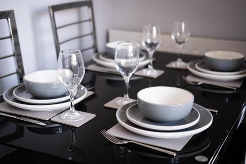 a black table with plates and wine glasses on it at Charming 2 bed in Aberchirder in Aberchirder