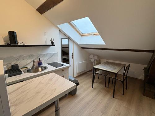 een keuken met een wastafel en een tafel met een raam bij Studios 4 nations in Épinal