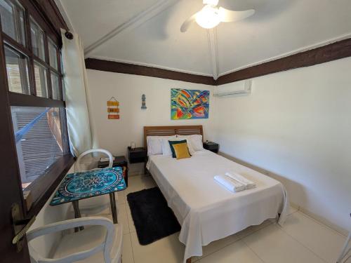 a bedroom with a bed and a chair in it at Marina Beach Guest House in Búzios