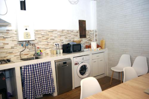 Refugio tranquilo cerca de las piscinas في كانديليدا: مطبخ مع حوض وغسالة ملابس