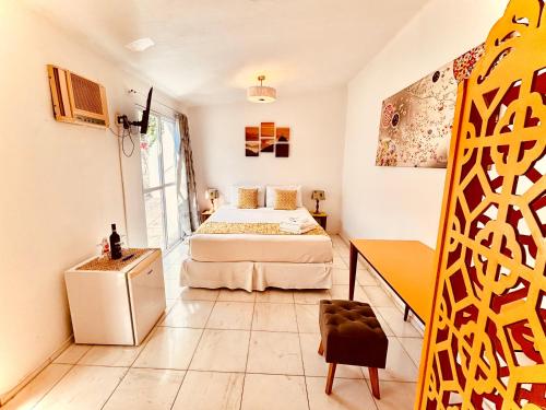 a bedroom with a bed and a table in a room at Les Jardins de Rio in Rio de Janeiro