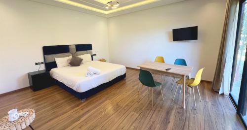 um quarto com uma cama, uma mesa e cadeiras em Maison d'Hotes Oasis Marrakech Route dOuarzazate em Oulad Akkou