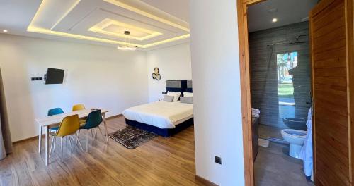 um quarto com uma cama, uma secretária e um WC em Maison d'Hotes Oasis Marrakech Route dOuarzazate em Oulad Akkou