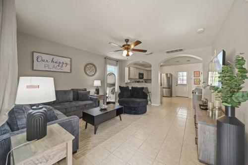 a living room with blue couches and a kitchen at Our Happy Place in Humble