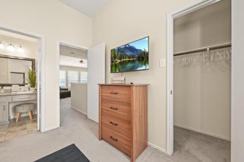 a bathroom with a dresser with a television on the wall at Our Happy Place in Humble
