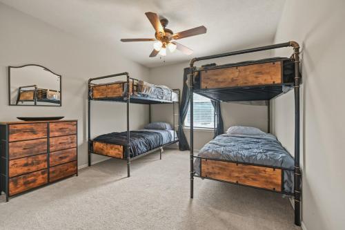 a bedroom with two bunk beds and a ceiling fan at Our Happy Place in Humble