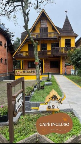 a yellow house with a sign in front of it at Hotel Pousada do Mel in Gramado