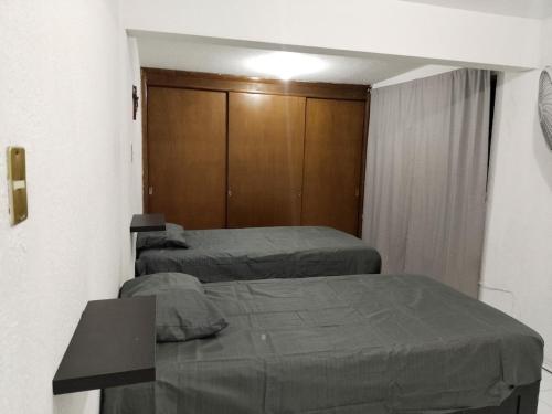 Habitación con 2 camas y armario de madera. en Casa para Vacaciones o estancia de trabajo para 4 -5 personas, en Chihuahua