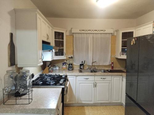 Una cocina con gabinetes blancos y un horno de estufa. en Casa para Vacaciones o estancia de trabajo para 4 -5 personas, en Chihuahua