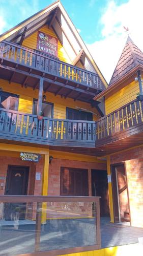 a yellow building with a balcony on top of it at Hotel Pousada do Mel in Gramado